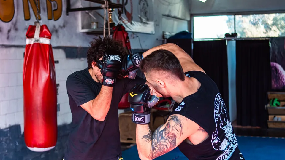 Two people sparring in a gym